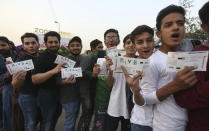 Pakistani cricket fans show their tickets stand in a queue to enter National Stadium to watch Pakistan Super League match in Karachi, Pakistan, Thursday, Feb. 20, 2020. (AP Photo/Fareed Khan)