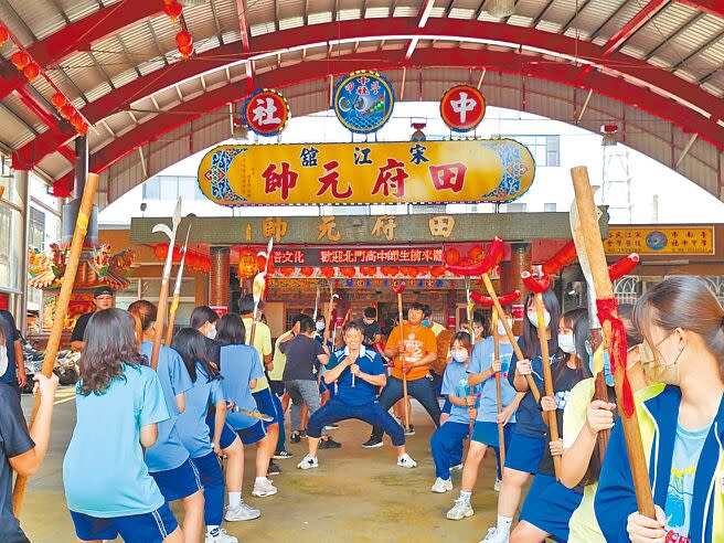 台南北門高中的學生在師傅指導之下，手拿宋江陣兵器，動作一致、齊聲吶喊，展現出青年氣勢。（張毓翎攝）