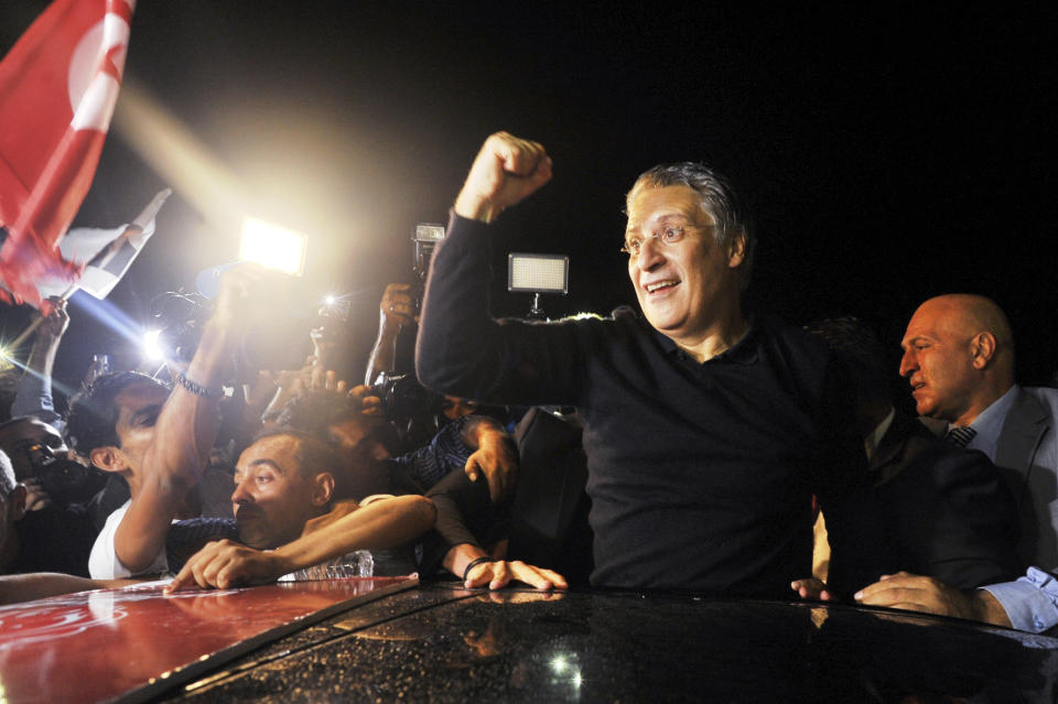 Tunisian presidential candidate and media mogul Nabil Karoui, waves as he is greeted by jubilant crowds after he was released from prison in Mannouba, Tunisia, Wednesday Oct. 9, 2019, just four days before the upcoming presidential runoff election. Karoui has been jailed since August under investigation for alleged money laundering and tax fraud that he asserts as a politically motivated smear campaign. (AP Photo)