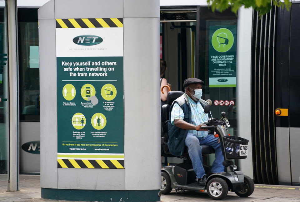 A member of the public wearing a mask riding a mobility scooter gets off the tram in Nottingham, during the easing of lockdown restrictions in England. Picture date: Wednesday July 14, 2021.