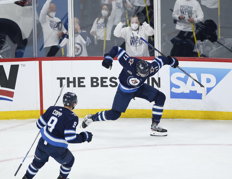 Winnipeg Jets' Adam Lowry (17) celebrates his goal against the Montreal Canadiens with Andrew Copp (9) during the first period of Game 1 of an NHL hockey Stanley Cup second-round playoff series Wednesday, June 2, 2021, in Winnipeg, Manitoba. (John Woods/The Canadian Press via AP)