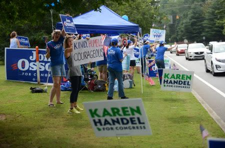 Supporters for Georgia 6th Congressional District Democratic candidate Jon Ossoff rally and wave at passing cars amid signs for Republican candidate Karen Handel outside St Mary's Orthodox Church, Handel's polling place in Roswell, Georgia, U.S., June 20, 2017. REUTERS/Bita Honarvar