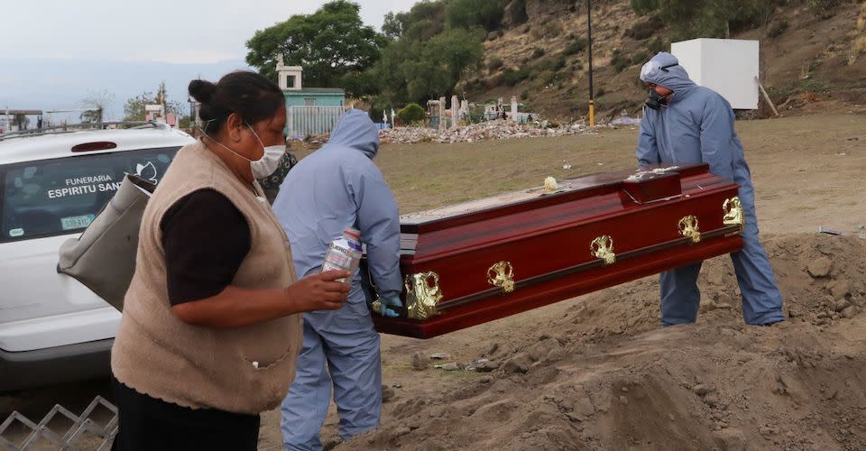 Dos trabajadores de funeraria cargaron un ataúd ce una muerte probable de Covid-19 en el Panteón Municipal Xico