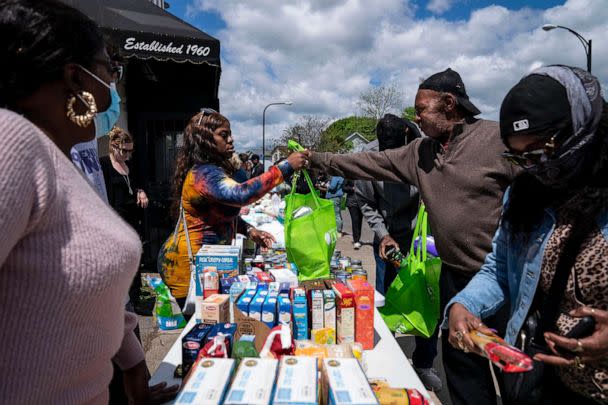 PHOTO: People pick up food and supplies from a food distribution event put on by Buffalo Community Fridge along Ferry street, just blocks away from Tops Friendly Market, on May 17, 2022, in Buffalo, N.Y. (Kent Nishimura/Los Angeles Times via Getty Images)