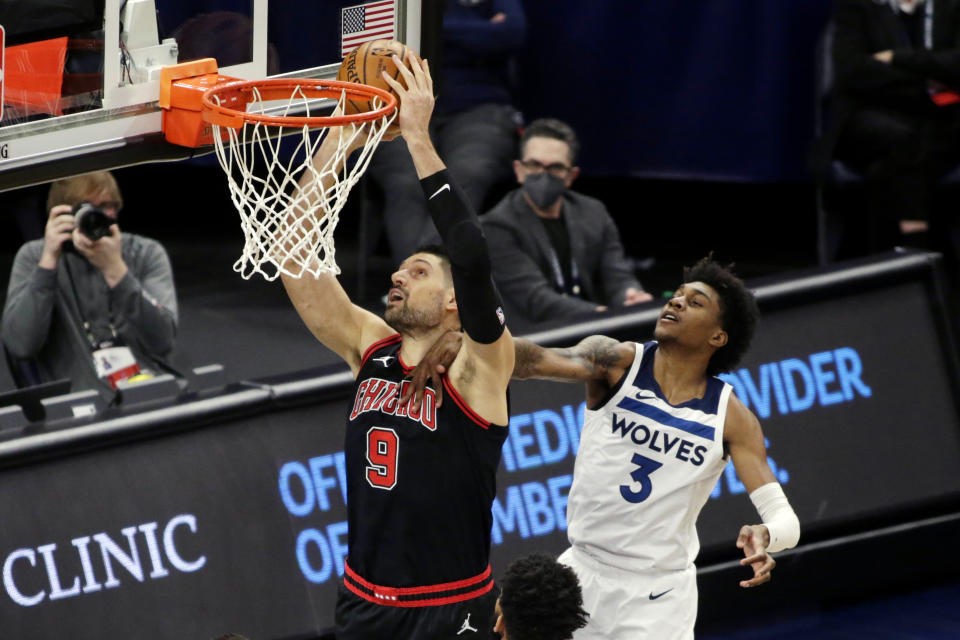 Chicago Bulls center Nikola Vucevic (9) is fouled by Minnesota Timberwolves forward Jaden McDaniels (3) in the first quarter of an NBA basketball game, Sunday, April 11, 2021, in Minneapolis. (AP Photo/Andy Clayton-King)