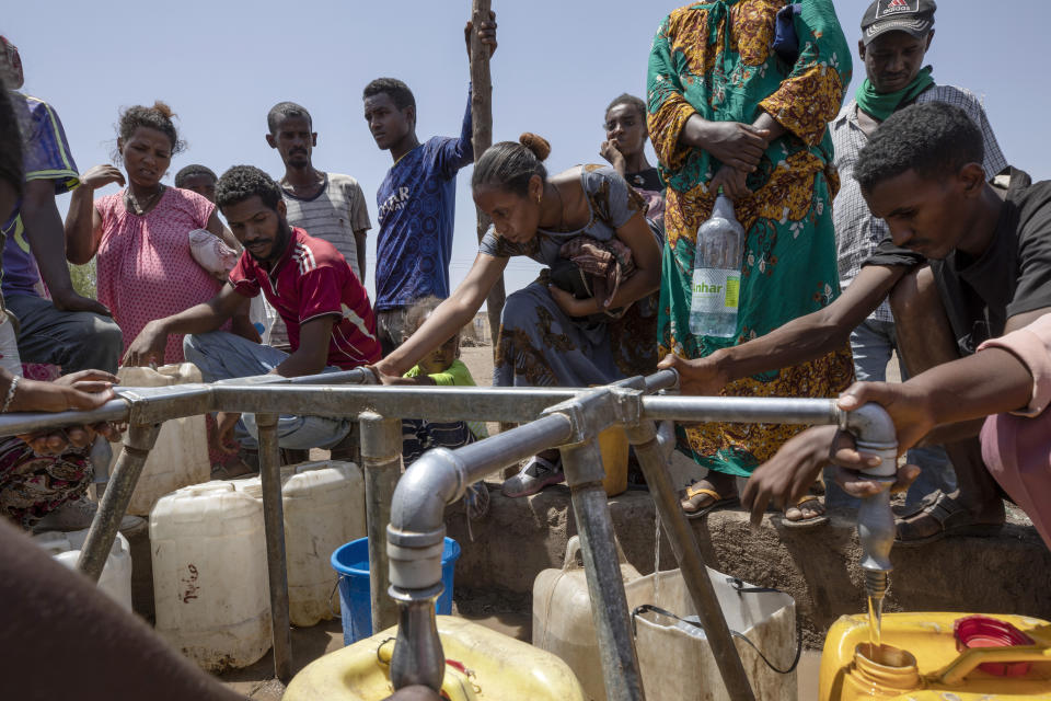 Elsa Tesfa Berhe, 26, center, a reproductive health official from Adwa, collects water a day after arriving from Humera to Hamdayet, eastern Sudan, near the border with Ethiopia, on March 16, 2021. Reusing gloves and rationing water, Berhe treated women secretly after Eritrean soldiers swept through health centers, looting even the beds and telling patients to leave. As she snuck out to deliver babies and treat the wounded, she saw people trying to bury bodies at the risk of being shot, or pouring alcohol on corpses in an attempt to hide the smell. (AP Photo/Nariman El-Mofty)