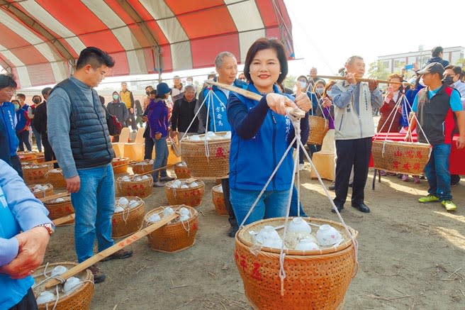 雲林縣長張麗善依習俗扛飯擔進場，象徵歡迎陣頭與民眾。（周麗蘭攝）