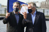 FILE - In this April 8, 2021 file photo, former Virginia Gov. Terry McAuliffe, right, gestures during a news conference with Virginia Gov.Ralph Northam, left, at Waterside in Norfolk, Va. McAuliffe won Virginia's 2013 governor's race by embracing his own brand of personal politics that rely on decades-old friendships, back-slapping charisma and tell-it-like-it-is authenticity. (AP Photo/Steve Helber, File)