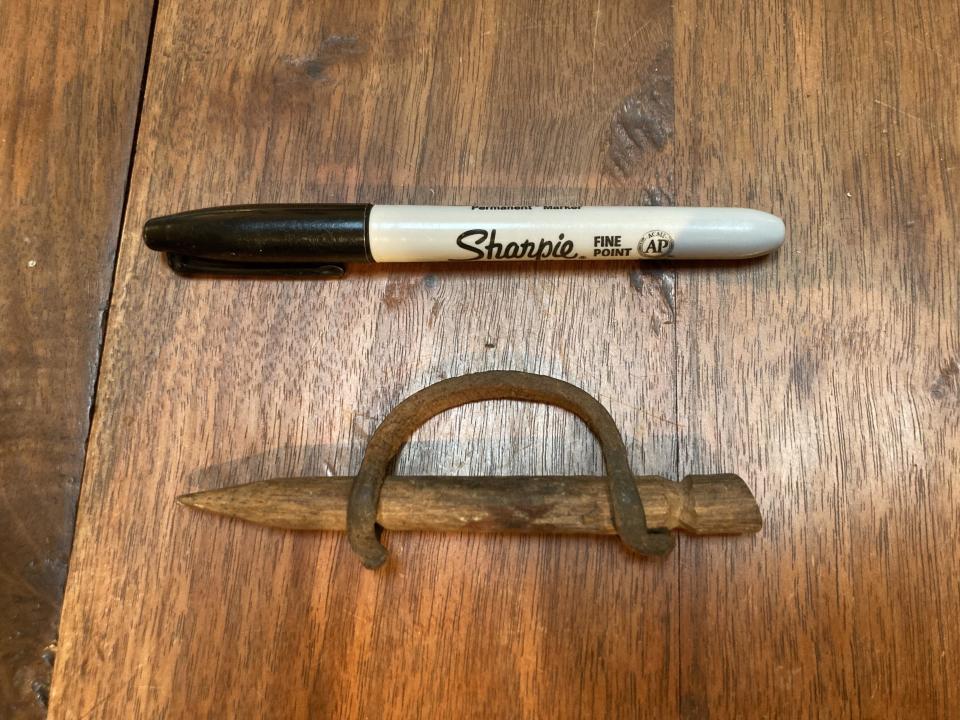 A black Sharpie marker and a wooden carpenter's pencil with a metal handle are placed on a wooden surface