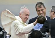 Pope Francis (L) greets a boy next to Ecuador President Rafael Correa (C) upon arrival at the airport in Quito on July 5, 2015