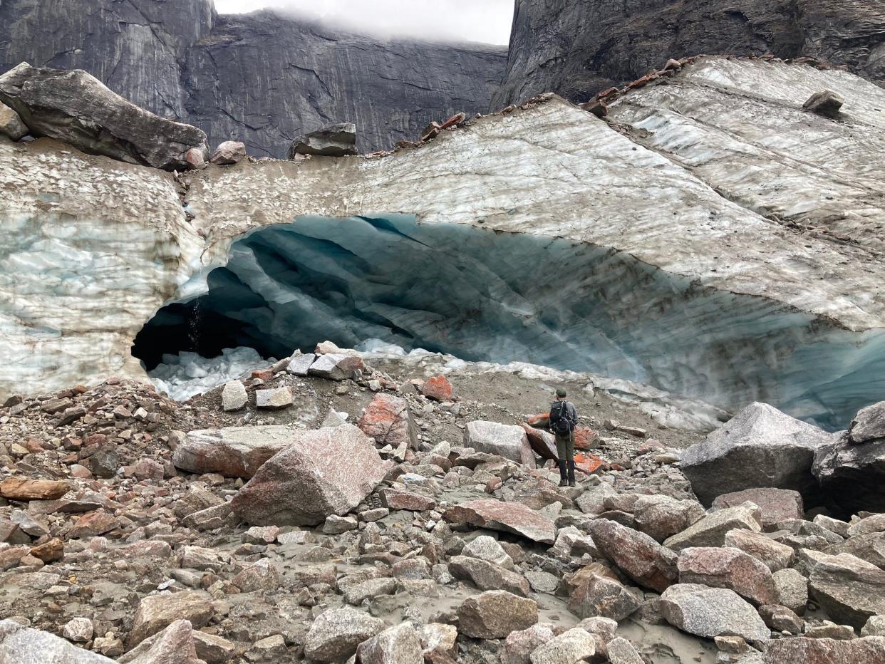 A ranger peers into an ice cave while patrolling the backcountry in Arrigetch Valley.