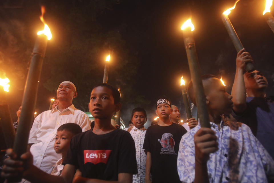 Muslim youths hold torches during a parade ahead of the beginning of the holy month of Ramadan in Medan, North Sumatra, Indonesia, Saturday, March 18, 2023. Muslims around the world will start to observe the holiest month in Islamic calendar next week during which they refrain from eating, drinking, smoking and sex from dawn to dusk. (AP Photo/Binsar Bakkara)