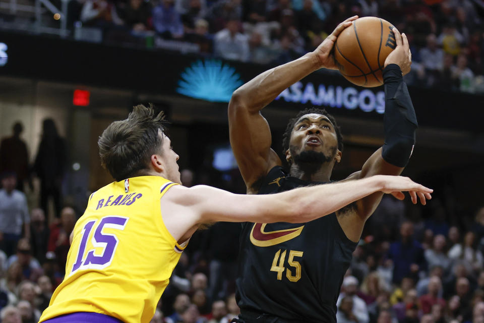 Cleveland Cavaliers guard Donovan Mitchell (45) shoots against Los Angeles Lakers guard Austin Reaves (15) during the second half of an NBA basketball game Tuesday, Dec. 6, 2022, in Cleveland. (AP Photo/Ron Schwane)