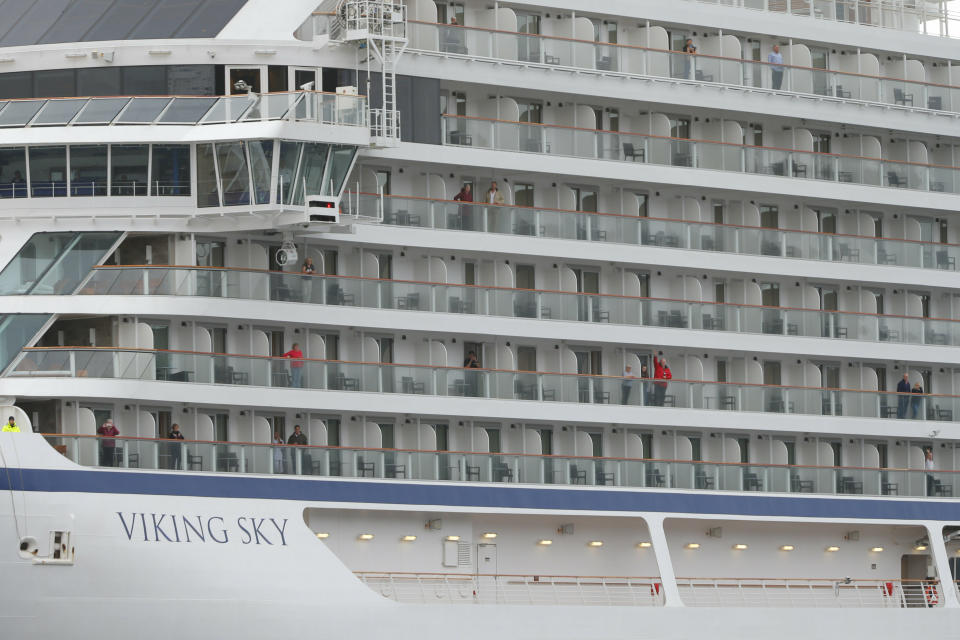Some of the remaining passengers look out as the cruise ship Viking Sky arrives at port off Molde, Norway, Sunday March 24, 2019, after having problems and issuing a Mayday call on Saturday in heavy seas off Norway's western coast. Rescue helicopters took more than 475 passengers from a cruise ship that got stranded off Norway's western coast in bad weather before the vessel departed for a nearby port under escort and with nearly 900 people still on board, the ship's owner said Sunday. (Svein Ove Ekornesvag/NTB scanpix via AP)