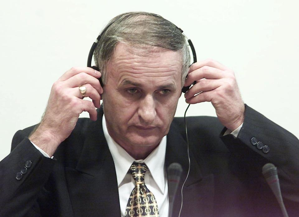 FILE - In this Thursday, Aug. 2, 2001 file photo, Bosnian Serb Gen. Radislav Krstic puts on headphones as he takes his seat in the courtroom in The Hague, Netherlands. The war criminal has been brought to Poland to serve out his sentence after he was assaulted in a British prison, a justice official said Friday March 21, 2014. Former general Radislav Krstic was convicted in 2001 and handed a 35-year prison sentence by the U.N. tribunal for the former Yugoslavia in The Hague, Netherlands, for aiding and abetting genocide over the 1995 killing of some 8,000 Muslims in Srebrenica, Bosnia. (AP Photo/Ed Oudenaarden, Pool, File)