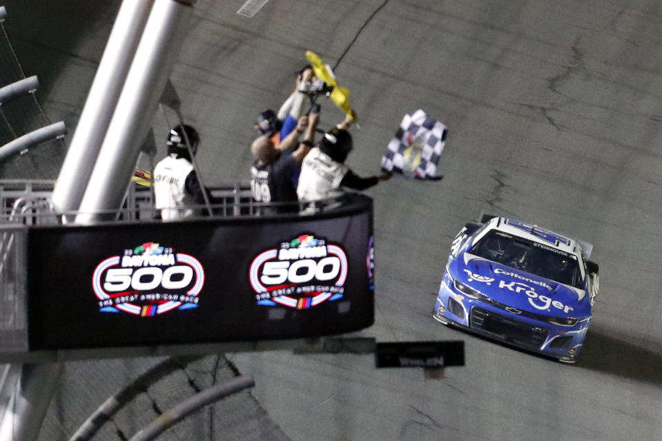 Ricky Stenhouse Jr. takes the checkered flag to win the NASCAR Daytona 500 auto race at Daytona International Speedway, Sunday, Feb. 19, 2023, in Daytona Beach, Fla. (AP Photo/David Graham)