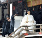 Japan's Emperor Naruhito, in a white robe, leaves after praying at “Kashikodokoro”, one of three shrines at the Imperial Palace, in Tokyo, Tuesday, Oct. 22, 2019. Emperor Naruhito visited three Shinto shrines at the Imperial Palace before proclaiming himself Japan’s 126th emperor in an enthronement ceremony. (Kyodo News via AP)