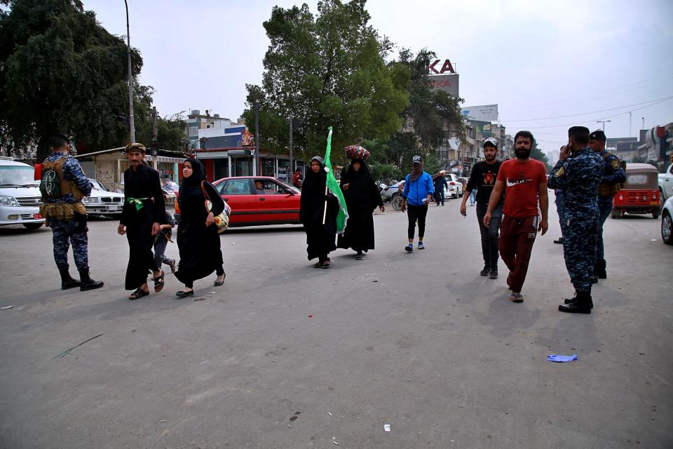 Although shrines are closed due to the new coronavirus, Shiite pilgrims make their way to the shrine of Imam Moussa al-Kadhim, a key Shiite saint, during preparations for the annual commemoration of his death, in Baghdad, Iraq Monday, March 16, 2020. Iraq announced a weeklong curfew late Sunday. People raced to supermarkets and swiftly emptied shelves, while others stocked up on cooking fuel. The curfew, which is set to begin late Tuesday, includes the suspension of all flights from Baghdad's international airport. For most people, the virus causes only mild or moderate symptoms. For some it can cause more severe illness. (AP Photo/Hadi Mizban)