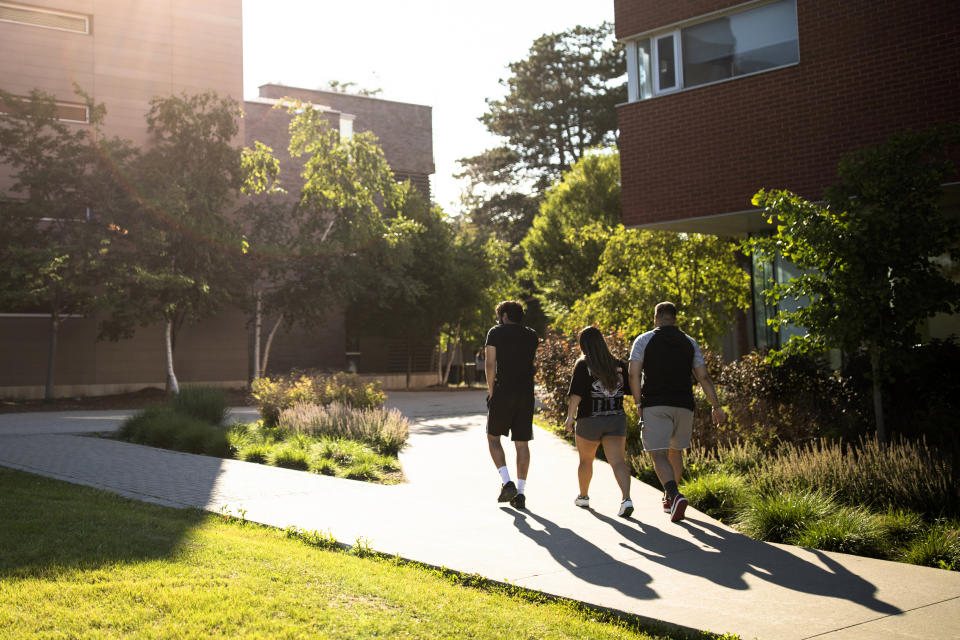 Students walk past the scene of a stabbing at the University of Waterloo, in Waterloo, Ontario, Wednesday, June 28, 2023. Waterloo Regional Police said three victims were stabbed inside the university's Hagey Hall, and a person was taken into custody. (Nick Iwanyshyn/The Canadian Press via AP)