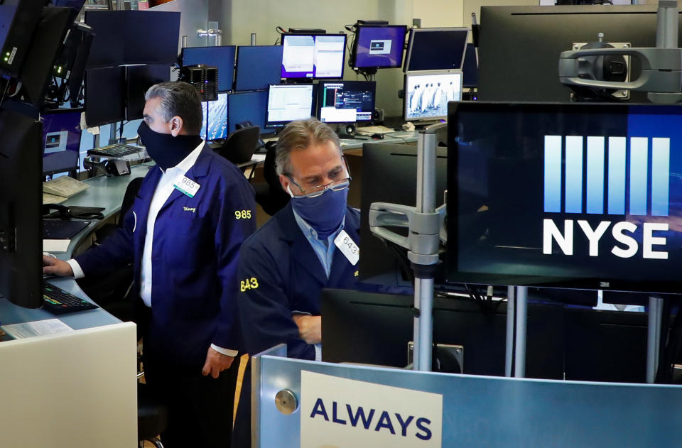 Traders wearing masks work, on the first day of in person trading since the closure during the outbreak of the coronavirus disease (COVID-19) on the floor at the New York Stock Exchange (NYSE) in New York, U.S., May 26, 2020. REUTERS/Brendan McDermid