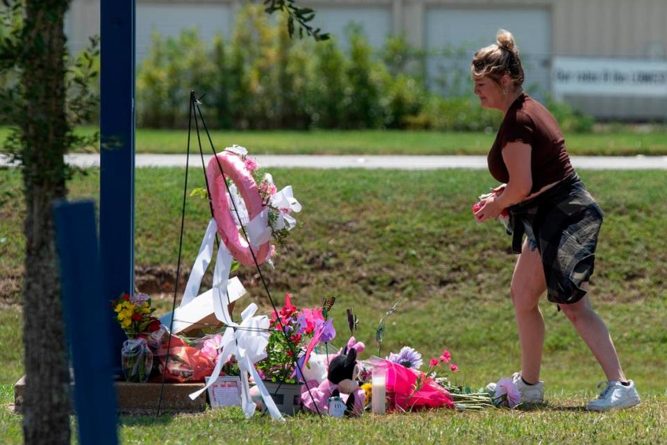 Vanessa Owens places tributes at a monument to a 13-year-old outside the Ocean Springs Middle School on Thursday, Sept. 7, 2023. The child, Aubreigh Wyatt, died unexpectedly after being bullied and her death is under investigation.