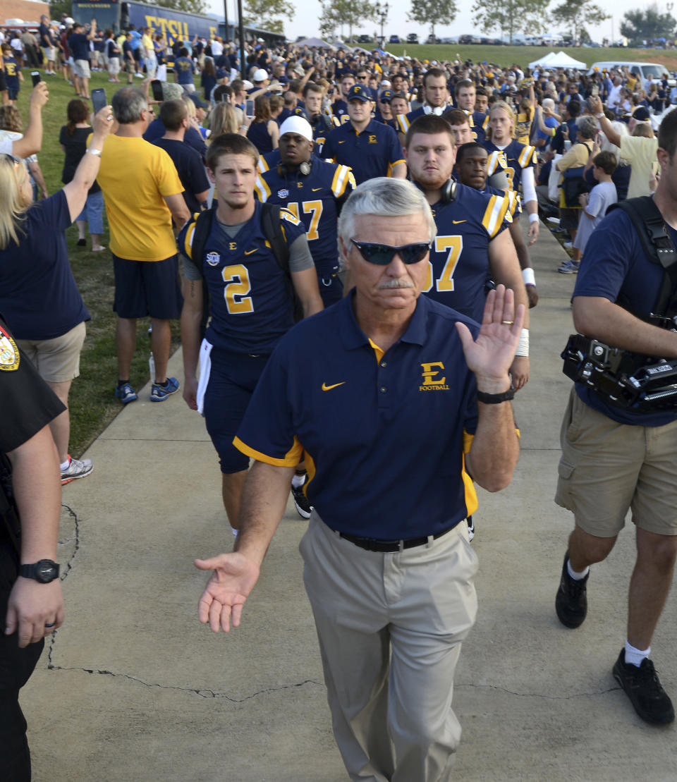 FILE - ETSU coach Carl Torbush leads his players to the field in the Buc Walk after arriving at Kermit Tipton Stadium for the team's first college football game since 2003, Thursday, Sept. 3, 2015, in Johnson City, Tenn. Torbush, a defensive specialist who succeeded Mack Brown as North Carolina's head football coach after Brown’s first tenure and later coached at East Tennessee State, has died. He was 72. ETSU said Monday that Torbush died Sunday, Nov. 5, 2023. (David Crigger/Bristol Herald Courier via AP, File)