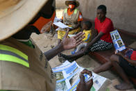 Community health worker, Rosemary Rambire, right, speaks to a young girl during a COVID-19 awareness campaign in Chitungwiza, on the outskirts of Harare, Wednesday, Sept. 23, 2020. As Zimbabwe's coronavirus infections decline, strict lockdowns designed to curb the disease are being replaced by a return to relatively normal life. The threat has eased so much that many people see no need to be cautious, which has invited complacency. That worries some health experts. Rosemary Rambire says the improving figures and the start of the searing heat of the Southern Hemisphere’s summer could undermine efforts to beat back the virus even further. (AP Photo/Tsvangirayi Mukwazhi)