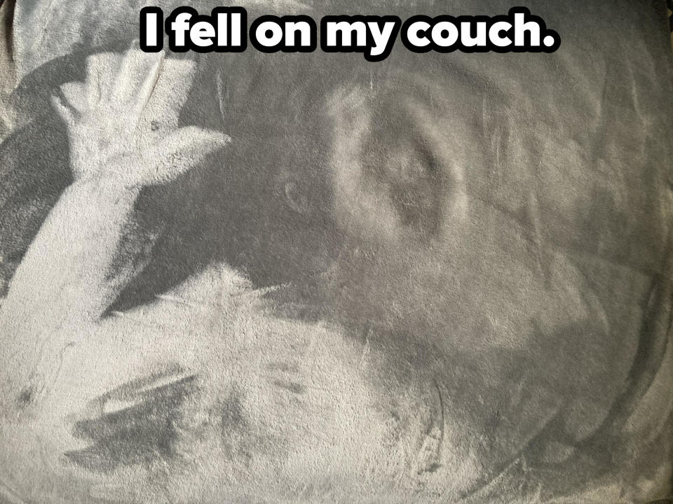 A person's hand and face imprinted on a couch