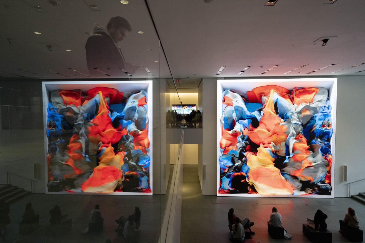 Visitors view artist Refik Anadol's "Unsupervised" exhibit at the Museum of Modern Art, Wednesday, Jan. 11, 2023, in New York. The new AI-generated installation is meant to be a thought-provoking interpretation of the New York City museum's prestigious collection. (AP Photo/John Minchillo)