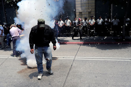 A demonstrator walks by fireworks during a protest against Guatemala's President Jimmy Morales outside the Congress in Guatemala City, Guatemala September 11, 2018. REUTERS/Luis Echeverria