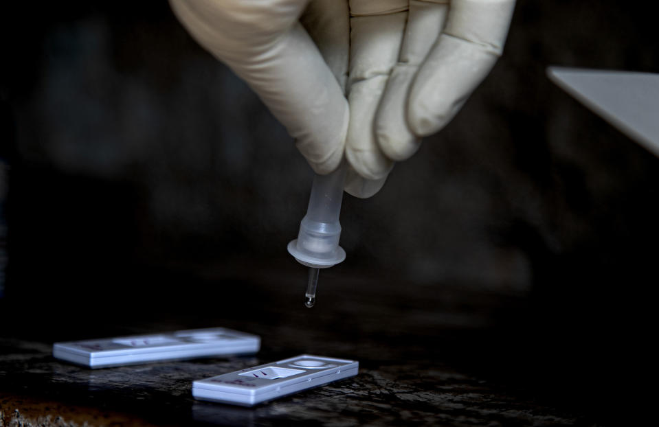 A health worker tests a sample for COVID-19 in a market in Gauhati, India, Friday, Oct. 16, 2020. India’s coronavirus fatalities jumped by 895 in the past 24 hours, a day after recording the lowest daily deaths of 680 in nearly three months. The Health Ministry on Friday also reported 63,371 new cases in the past 24 hours, raising India’s total to more than 7.3 million, second in the world behind the U.S. (AP Photo/Anupam Nath)