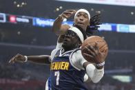 Denver Nuggets guard Reggie Jackson, below, tries to shoot as Los Angeles Clippers guard Terance Mann defends during the first half of an NBA basketball game Thursday, April 4, 2024, in Los Angeles. (AP Photo/Mark J. Terrill)