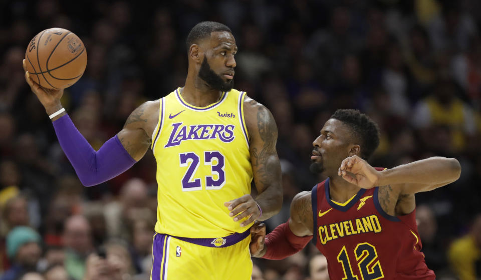 Los Angeles Lakers' LeBron James, left, looks to pass the ball as Cleveland Cavaliers' David Nwaba defends during the first half of an NBA basketball game Wednesday, Nov. 21, 2018, in Cleveland. (AP Photo/Tony Dejak)