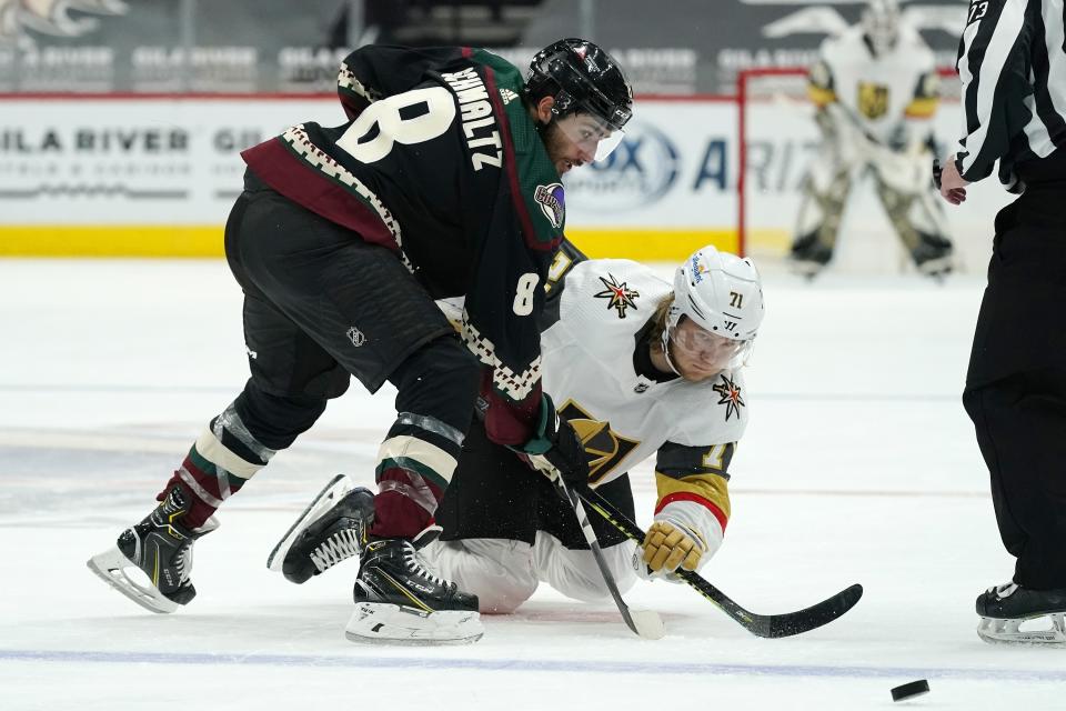 Arizona Coyotes center Nick Schmaltz (8) and Vegas Golden Knights center William Karlsson (71) battle for the puck during the second period of an NHL hockey game Friday, Jan. 22, 2021, in Glendale, Ariz. (AP Photo/Ross D. Franklin)