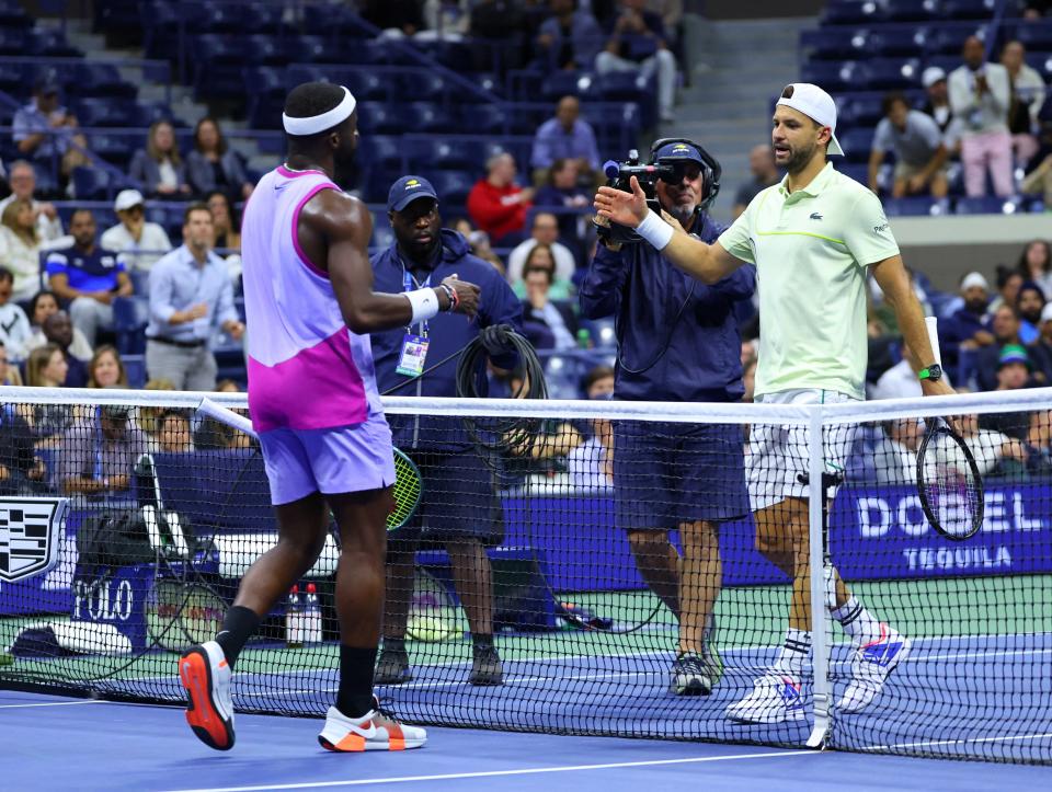 Dimitrov shakes hands with Tiafoe of the US after sustaining an injury and the walkover on his quarter final match (Reuters)