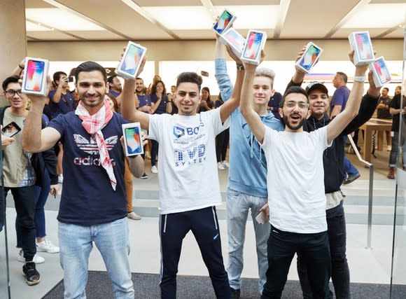 Apple customers holding new iPhone X devices on launch day