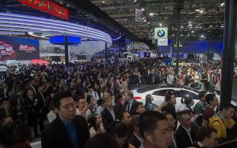 Crowds gather as BMW launches a new car at the Beijing auto show - Credit: AFP