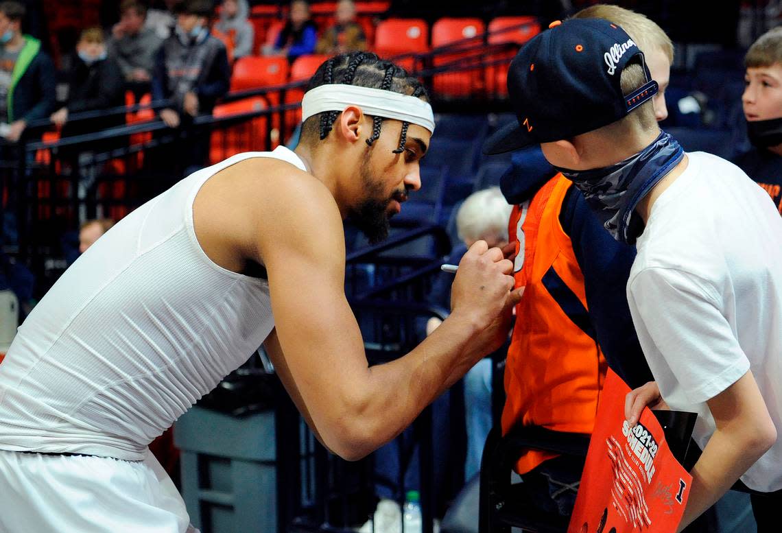 Illinois’ Jacob Grandison signs the back of a fan’s shirt before the start of their game against Purdue Monday, Jan. 17, 2022, in Champaign, Ill. Michael Allio/AP