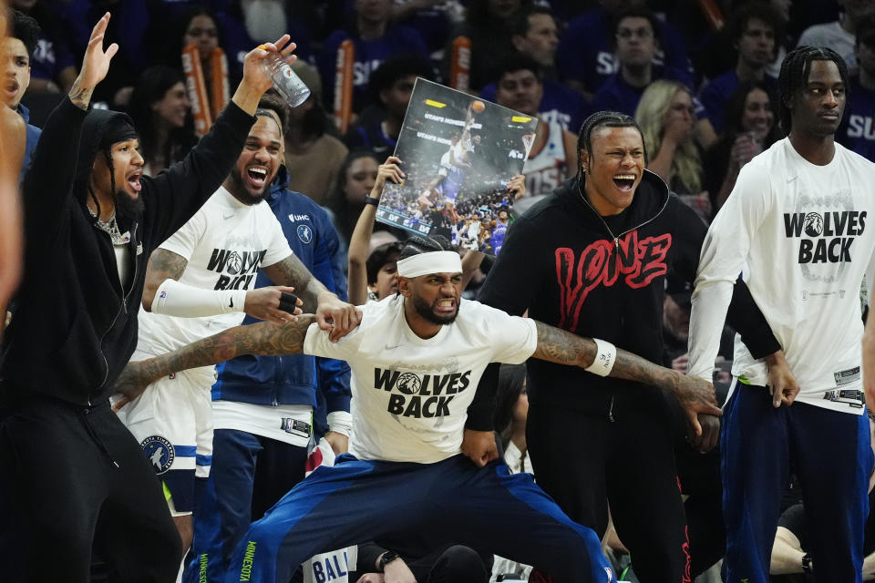 Minnesota Timberwolves players celebrate a score against the Phoenix Suns during the second half of Game 4 of an NBA basketball first-round playoff series, Sunday, April 28, 2024, in Phoenix. The Timberwolves won 122-116, taking the series 4-0. (AP Photo/Ross D. Franklin)