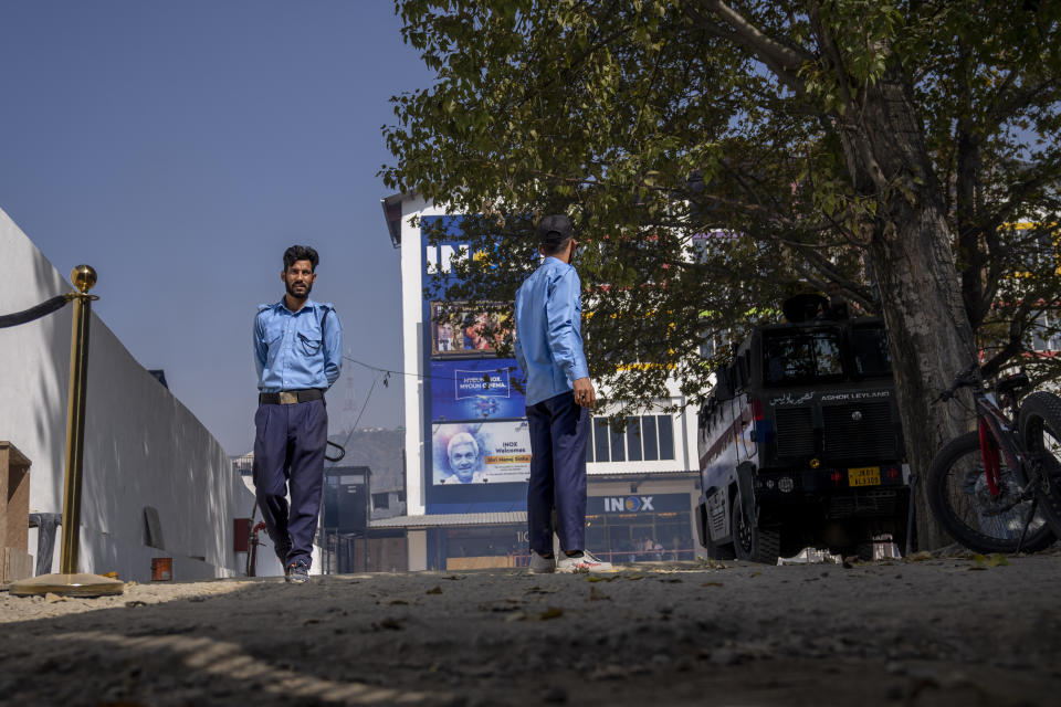 Security guards stand guard outside Kashmir's first multiplex cinema after it was opened to public in Srinagar, Indian controlled Kashmir, Saturday, Oct. 1, 2022. The multi-screen cinema hall has opened in the main city of Indian-controlled Kashmir for public for the first time in 14 years. The 520-seat hall with three screens opened on Saturday, amid elaborate security but only about a dozen viewers lined up for the first morning show. (AP Photo/Dar Yasin)