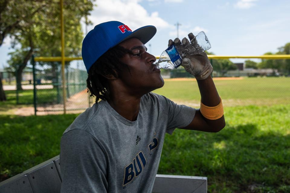 Prince Ferguson cools off in the shade and drinks water after batting practice at Pompey Park on Wednesday, June 28, 2023, in Delray Beach, Florida.