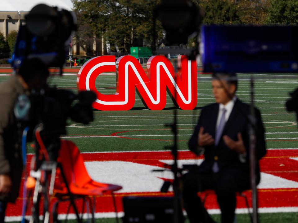 A journalist records video near a CNN sign on an athletic field outside the Clements Recreation Center where the CNN/New York Times will host the Democratic presidential primary debate at Otterbein University, Monday, Oct. 14, 2019, in Westerville, Ohio. (AP Photo/John Minchillo)