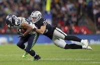 Seattle Seahawks wide receiver Doug Baldwin (89), left, is tackled by Oakland Raiders defensive back Erik Harris (25) during the second half of an NFL football game at Wembley stadium in London, Sunday, Oct. 14, 2018. (AP Photo/Tim Ireland)