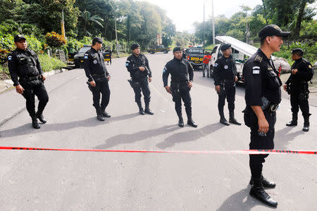 Police officers stand at a checkpoint to block access to an area affected by the eruption of the Fuego volcano at San Miguel Los Lotes in Escuintla, Guatemala June 7, 2018. REUTERS/Carlos Jasso