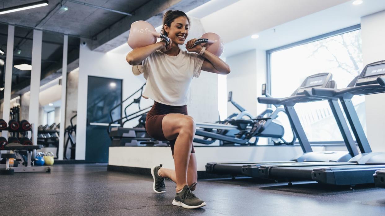  Woman does kettlebell workout. 