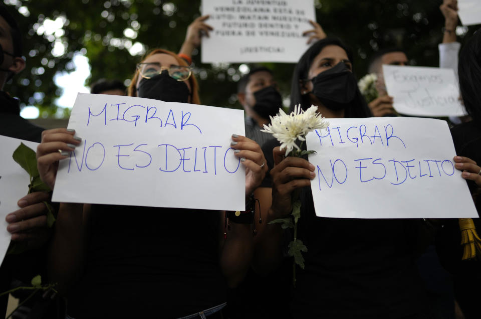 ARCHIVO - Mujeres sostienen carteles durante una protesta frente a la embajada de Trinidad y Tobago después de que agentes de la Guardia Costera de Trinidad estuvieran involucrados en el tiroteo contra un barco de migrantes donde murió un bebé venezolano y su madre resultó herida, en Caracas, Venezuela, el 8 de febrero de 2022. (AP Foto/Ariana Cubillos, Archivo)