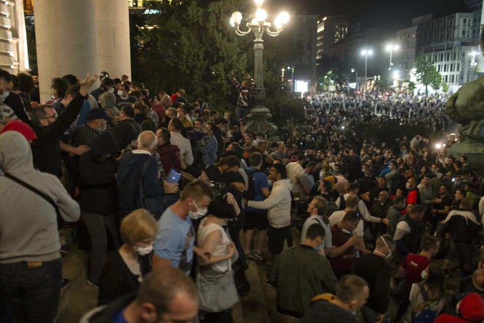 Protesters gather in front of the Serbian parliament in Belgrade, Serbia, Tuesday, July 7, 2020. Thousands of people protested the Serbian president's announcement that a lockdown will be reintroduced after the Balkan country reported its highest single-day death toll from the coronavirus Tuesday. (AP Photo/Marko Drobnjakovic)