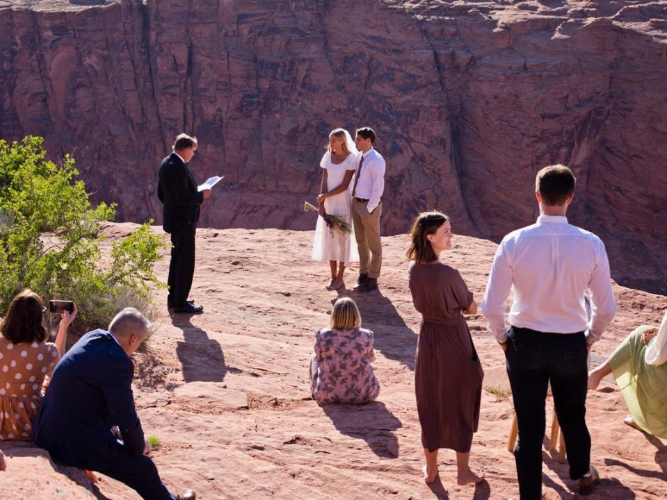 A couple getting married, with their family surrounding them.