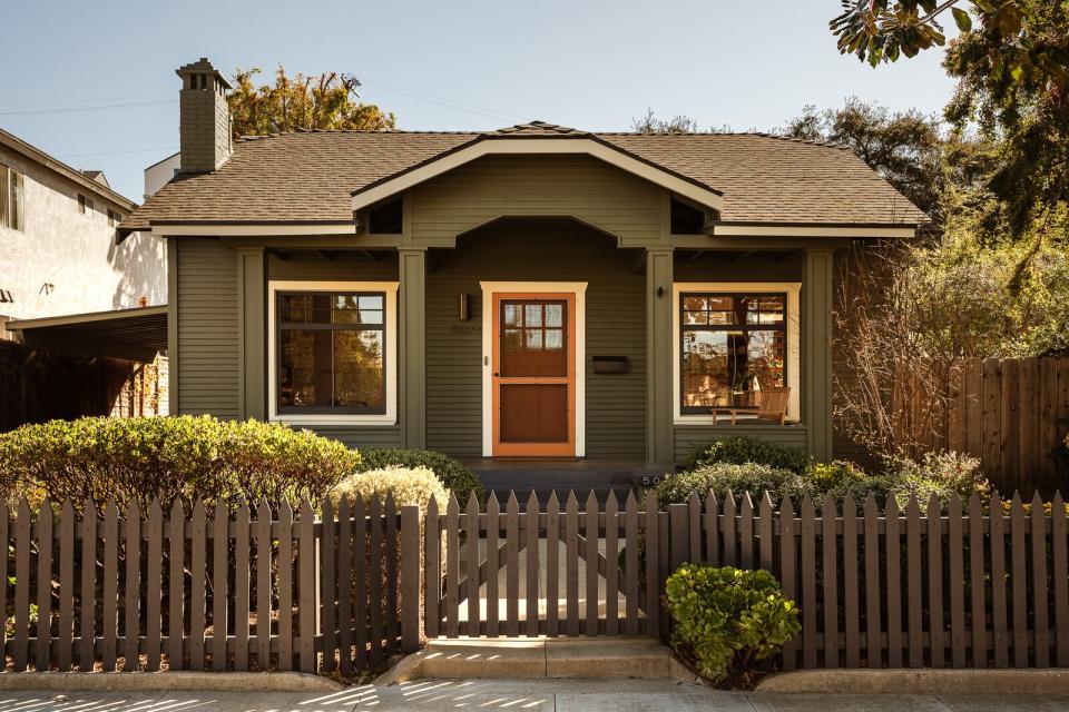 Nestled being a picket fence, the reimagined home sports a handsome dark-green facade.