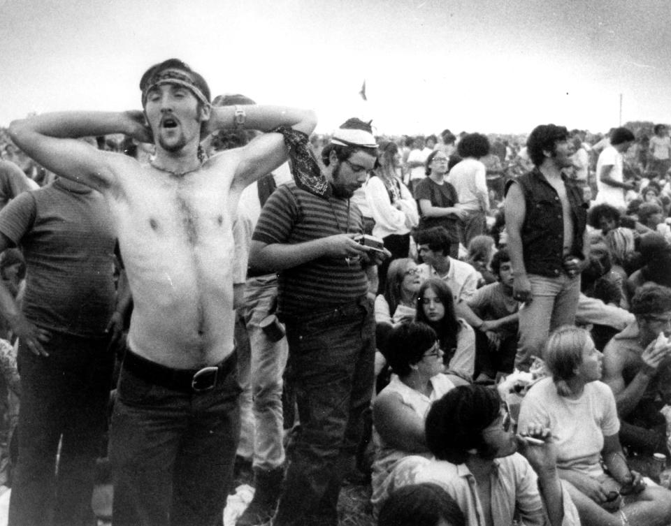 FILE - In this Aug. 16, 1969 file photo rock music fans relax during a break in the entertainment at the Woodstock Music and Arts Fair in Bethel, N.Y. Woodstock will be celebrated on its 50th anniversary, but it won't be your hippie uncle's trample-the-fences concert. While plans for a big Woodstock 50 festival collapsed after a run of calamities, the bucolic upstate New York site of the 1969 show is hosting a long weekend of events featuring separate shows by festival veterans like Carlos Santana and John Fogerty. (AP File Photo)